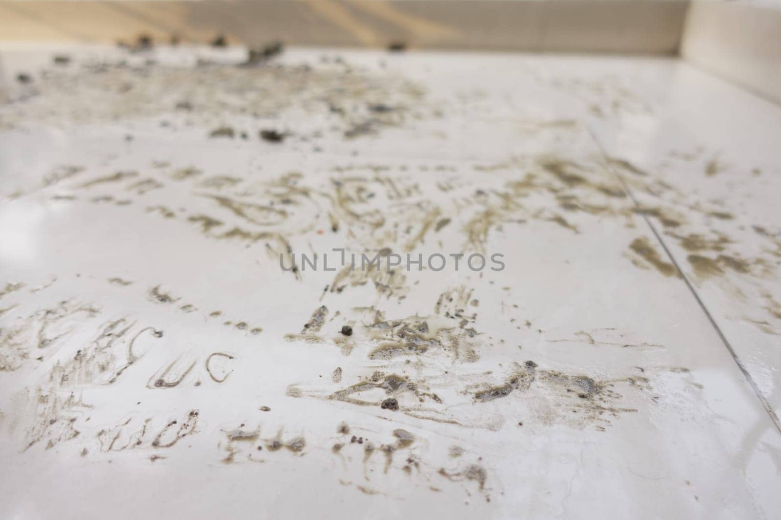 Creative marks and patterns made on a grimy white surface indoors.