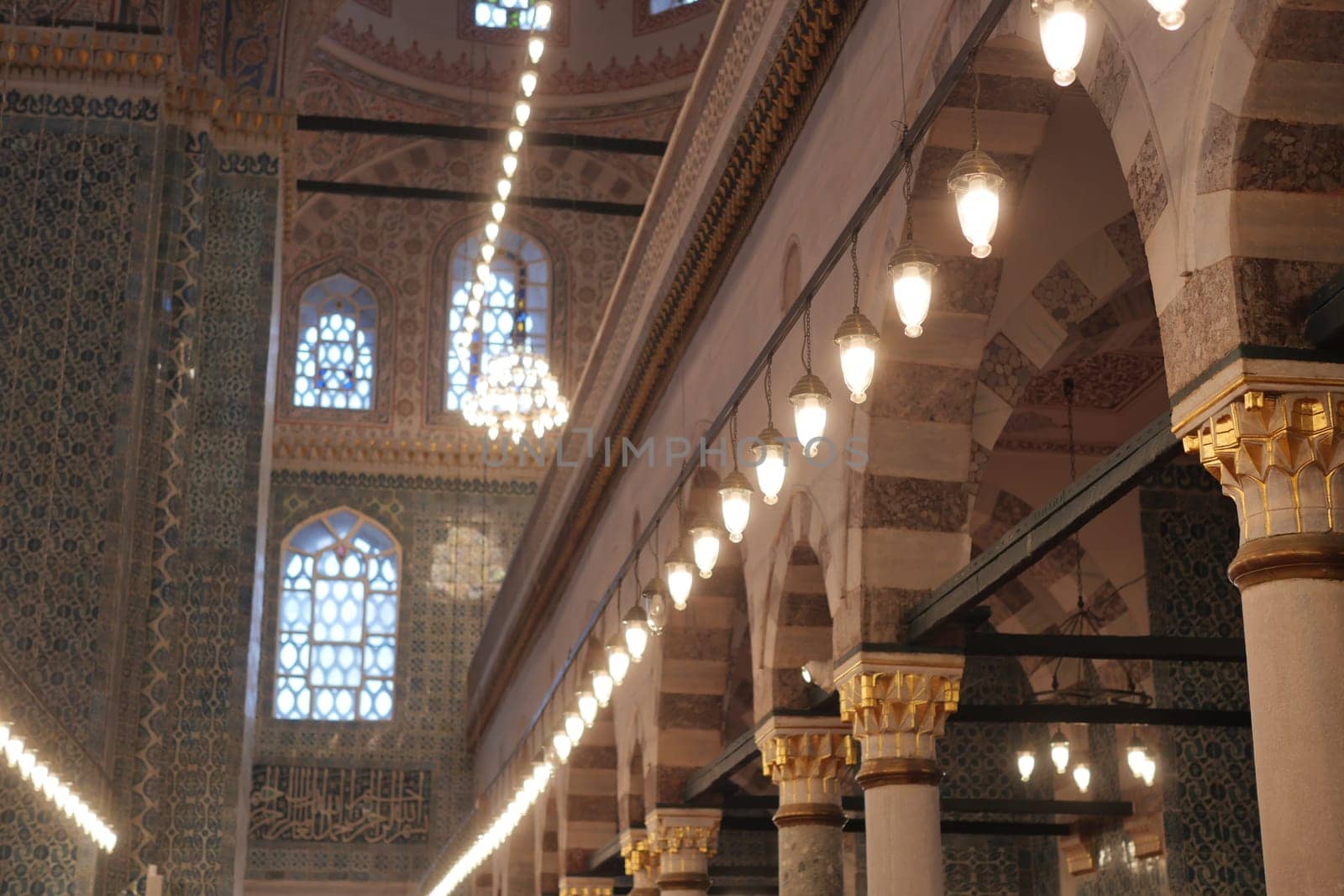 Stunning interior of a mosque showcases ornate arches and beautiful lights.