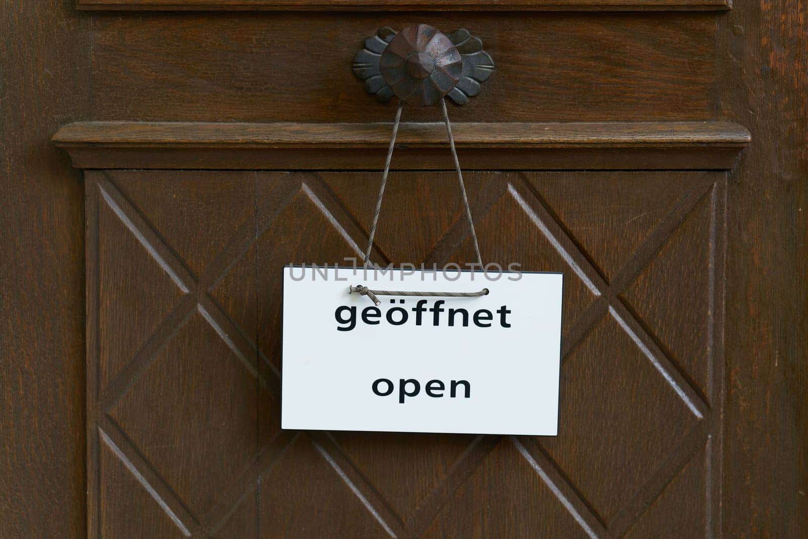 Sign on a entrance door of with the word open, geoffnet in German and English language