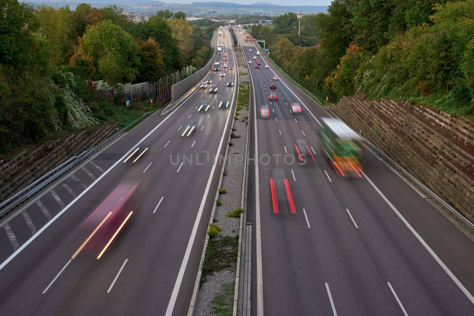 Long exposure photo of traffic with blurred traces from cars, top view. road, cars, blurred traffic, evening, top view. Highway at evening, blue hour illuminated by the traffic of cars by Andrii_Ko