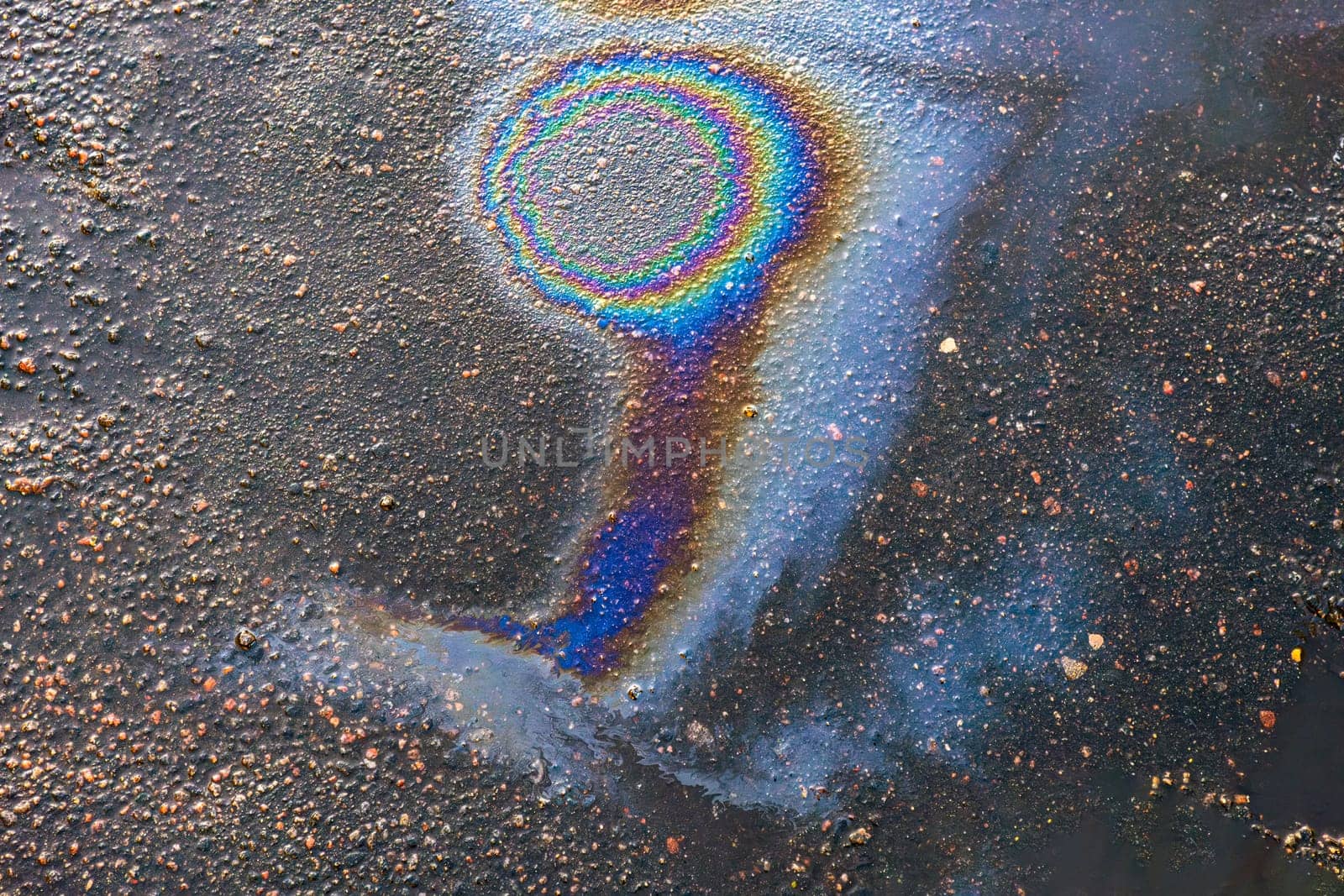 Gasoline or oil stains on an asphalt road as a texture or background.