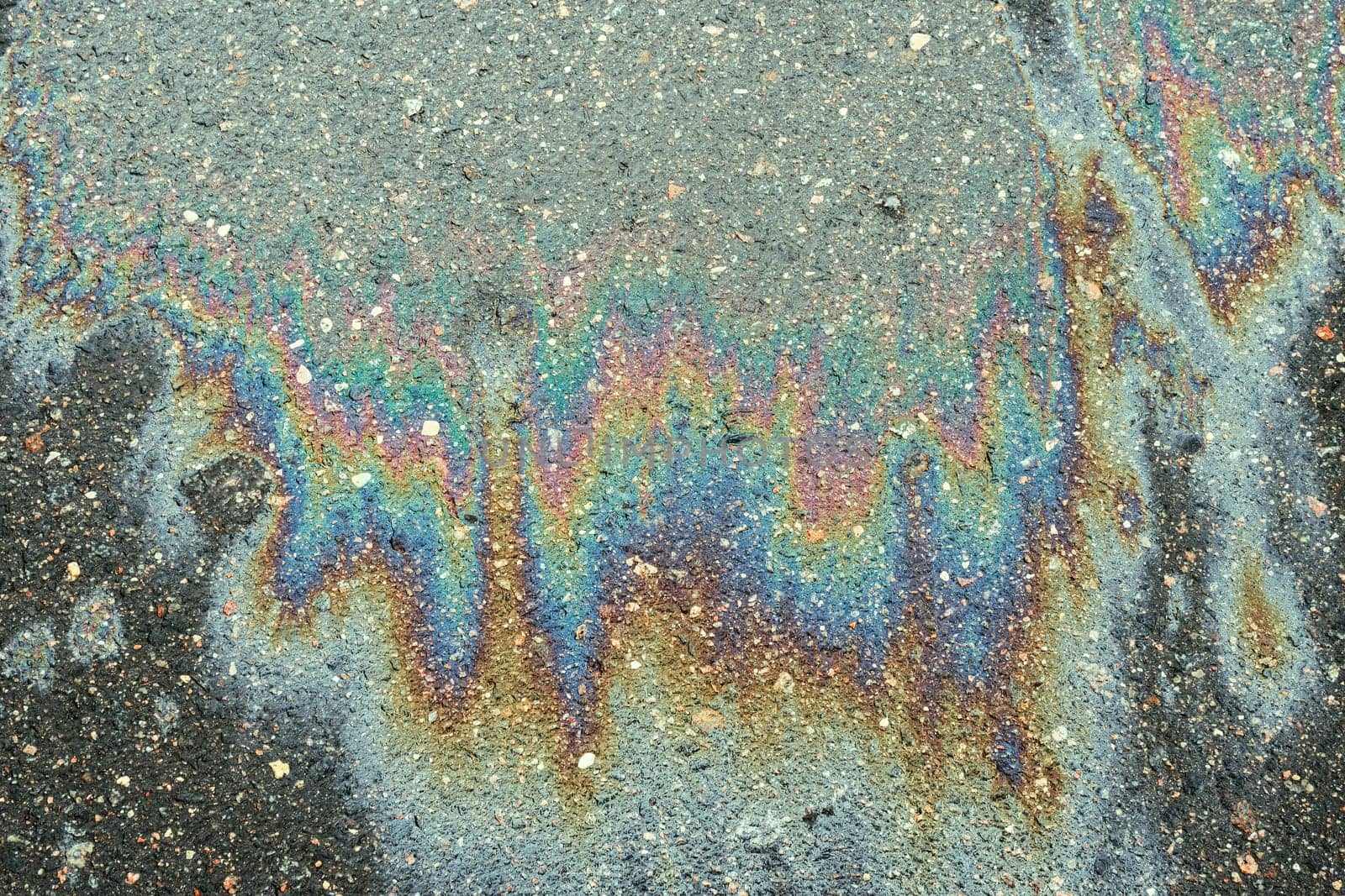 Spills of fuel or oil on the asphalt road as texture or background.