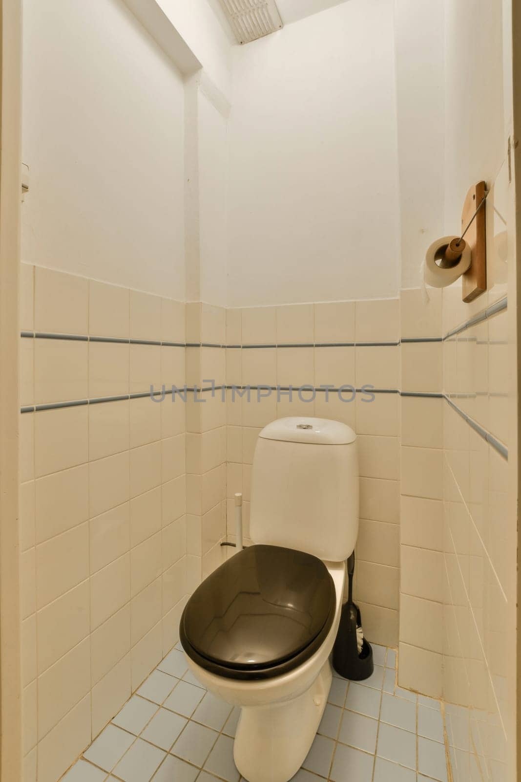 a toilet with a black seat in a white bathroom by casamedia