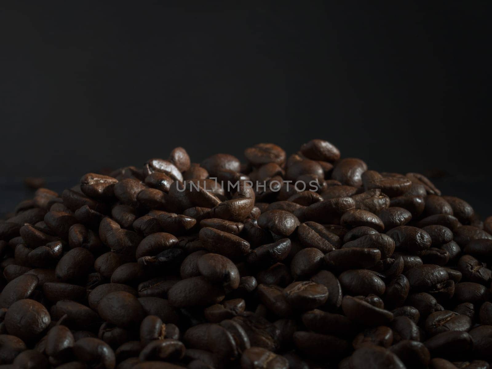 Brown roasted coffee beans, seed on dark background. Espresso dark, aroma, black caffeine drink. Closeup energy mocha, cappuccino ingredient.