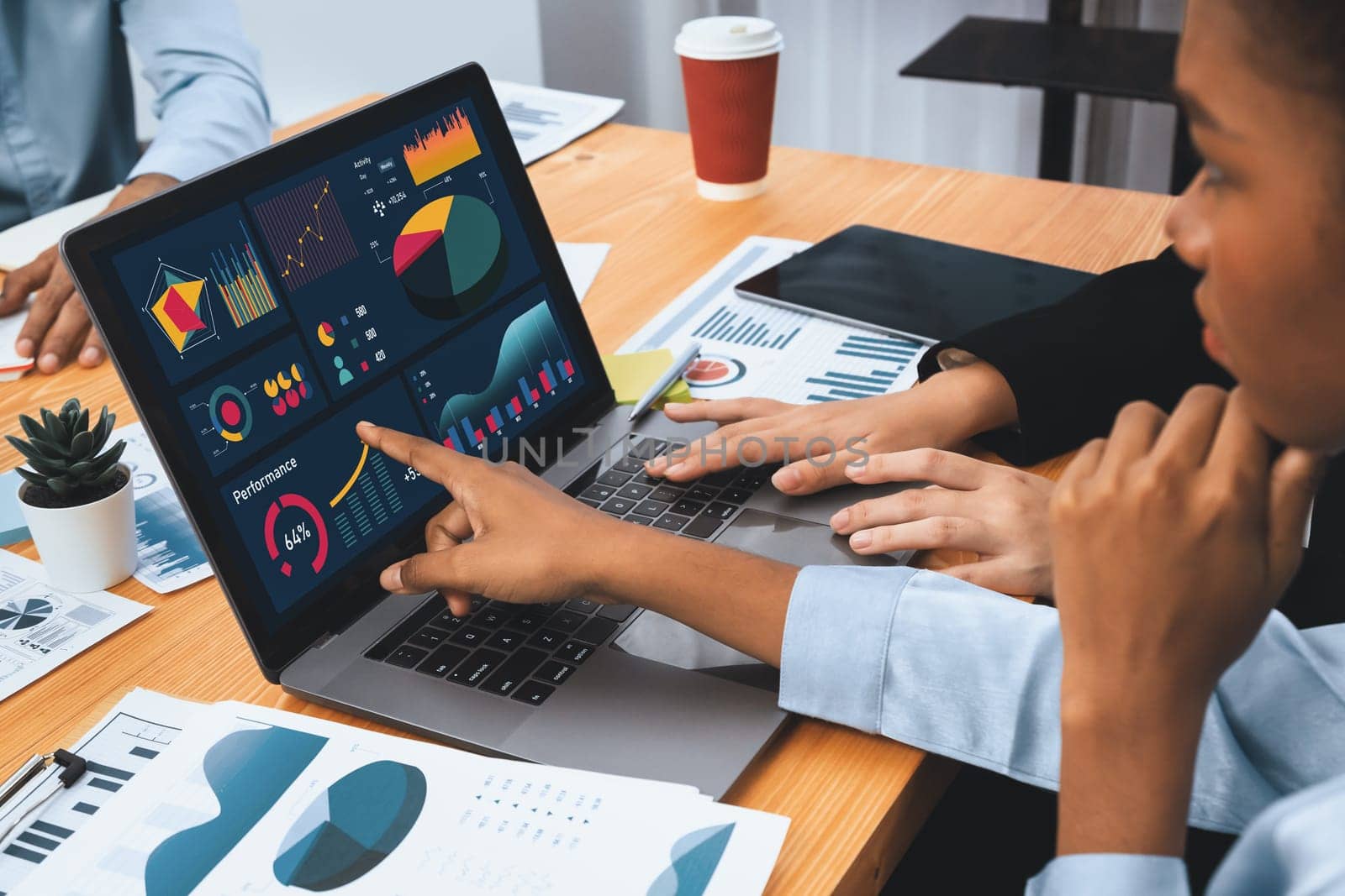 Multiracial analyst team use BI Fintech software to analyze financial data on meeting table. Financial dashboard data display on laptop screen with analyzed chart for marketing indication. Concord