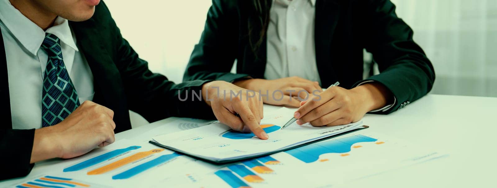 Business people in group meeting in formal attire share idea discussing report for company profit in creative workspace for start up business shot in close up view on group meeting table . Oratory .