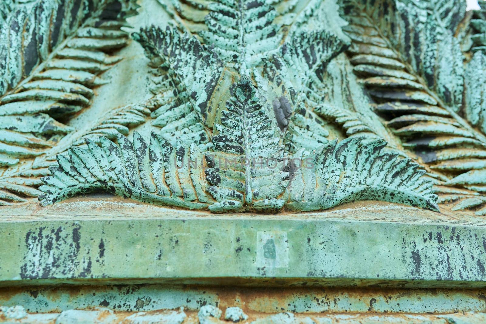 Close-up of an old vintage fragment of a monument, pastille ornament in green color, green old copper