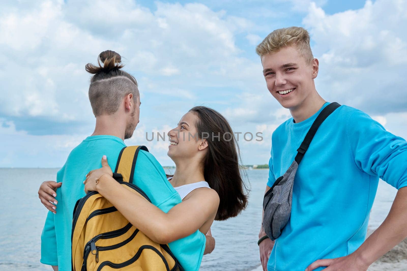 Outdoor teenage friends meeting, hugging teenagers on the beach. Youth, vacation, leisure, friendship, fun, lifestyle holiday concept