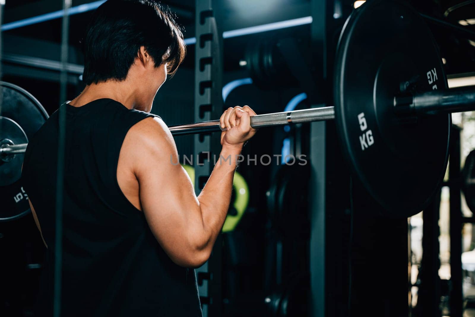 A fit and strong male athlete in sportswear, holding a barbell and lifting weights for a functional and endurance-based workout in the gym. power lifting training concept