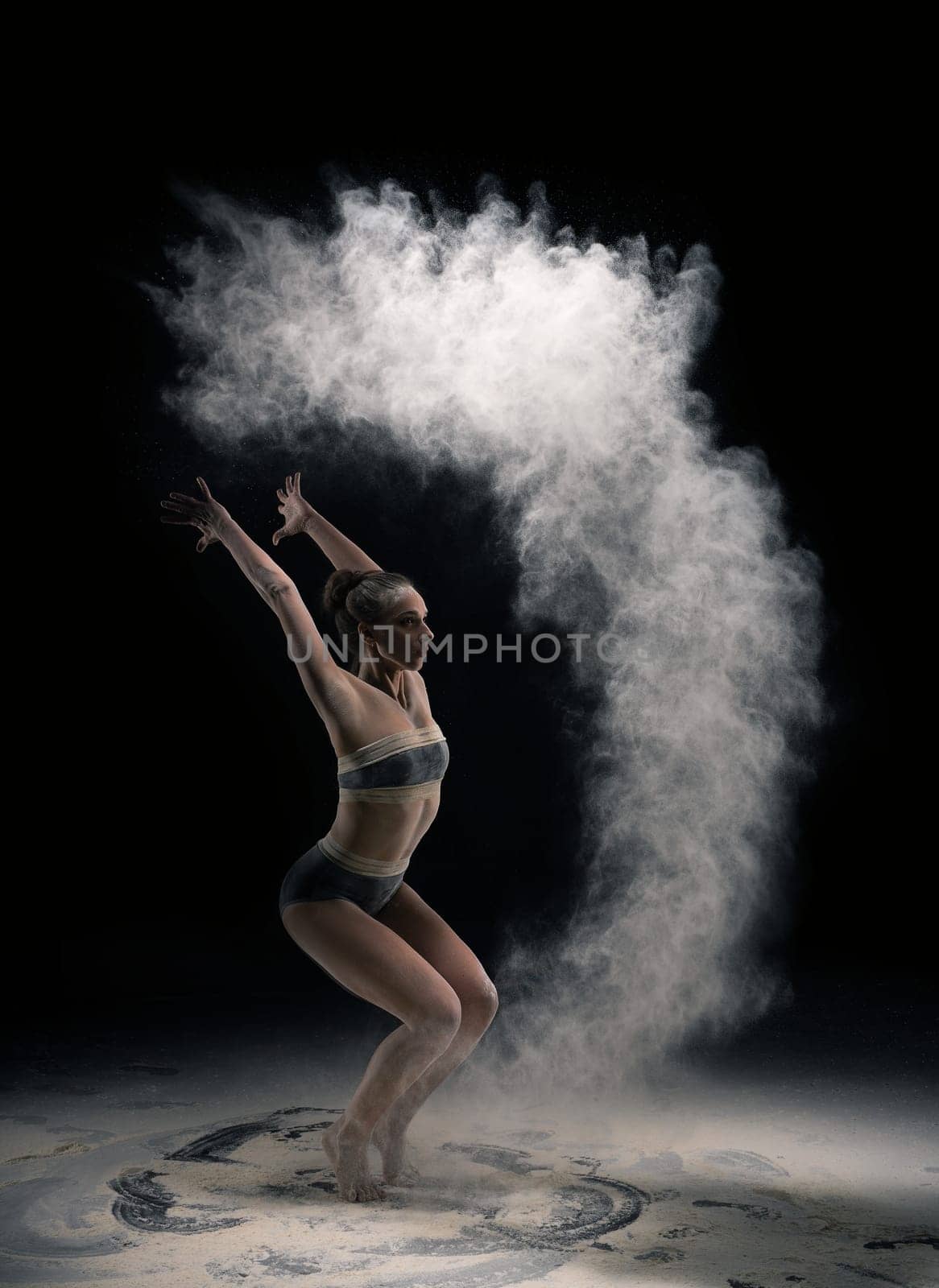 Full length slim mid age in bra and panties throwing sand in air during yoga exercise