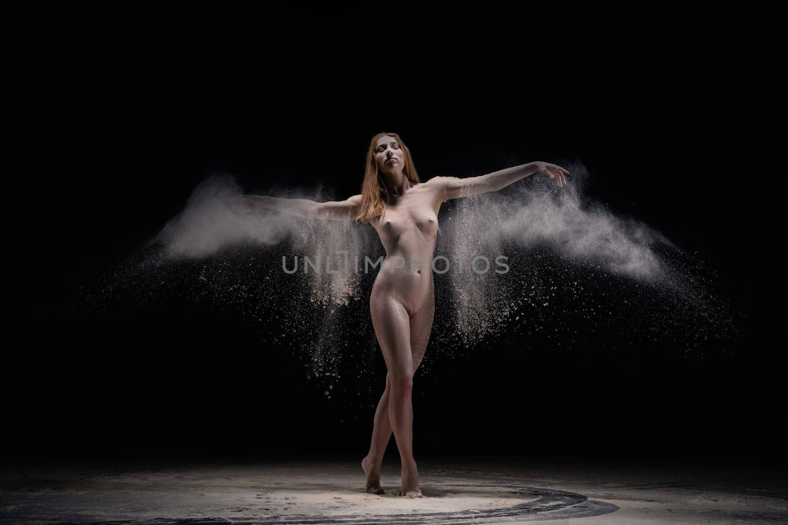 Full length naked woman throw dust in dark
