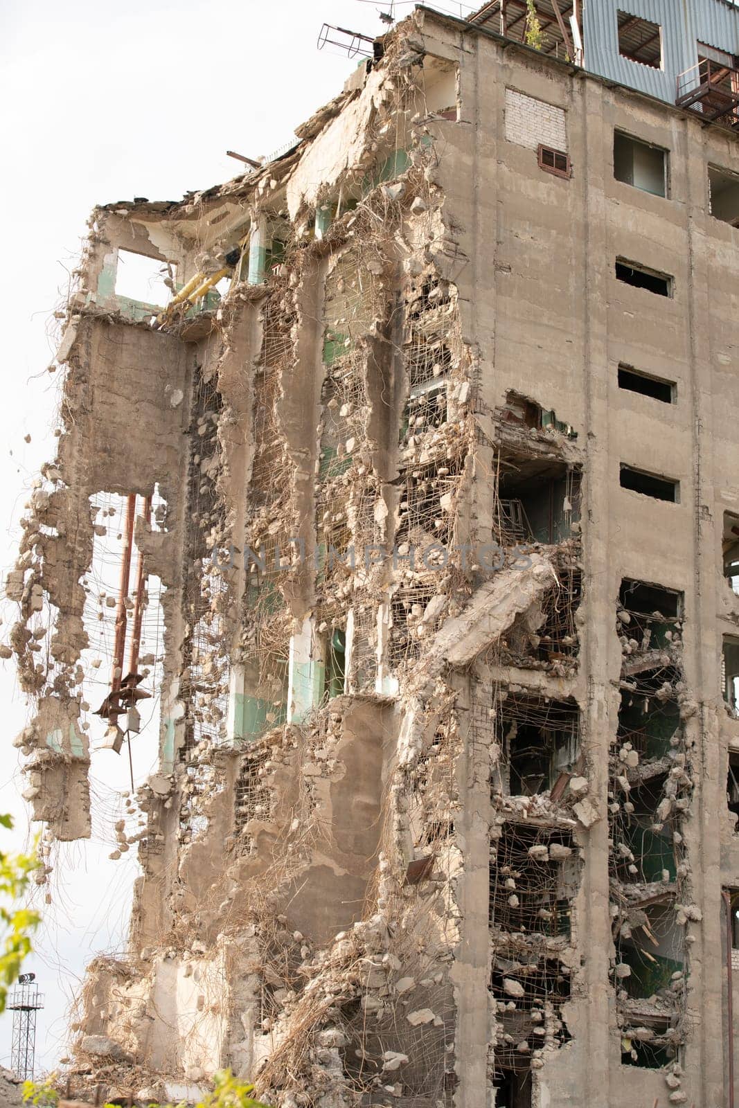 Exterior of damaged abandoned building with crumbling cement walls located against gray sky