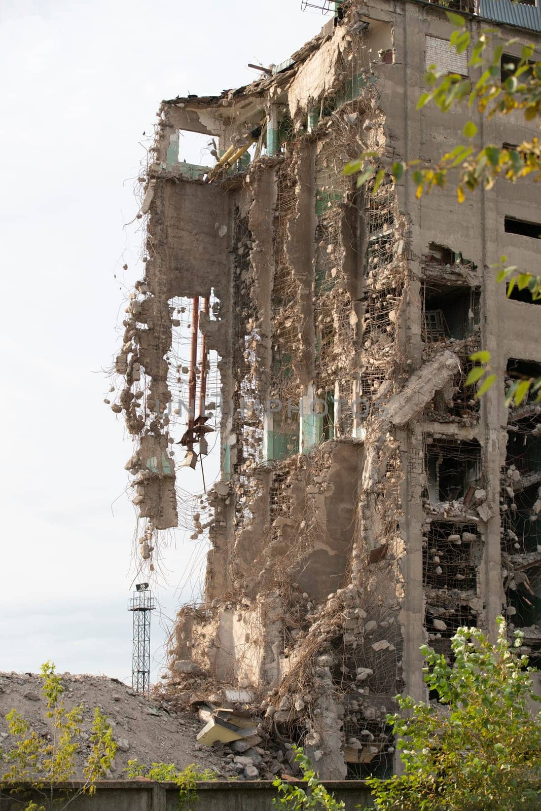 Exterior of damaged abandoned building with crumbling cement walls located against gray sky