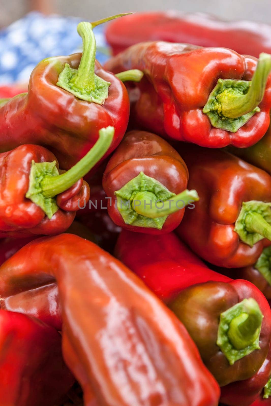 A pile of red bell peppers on display at a market.
