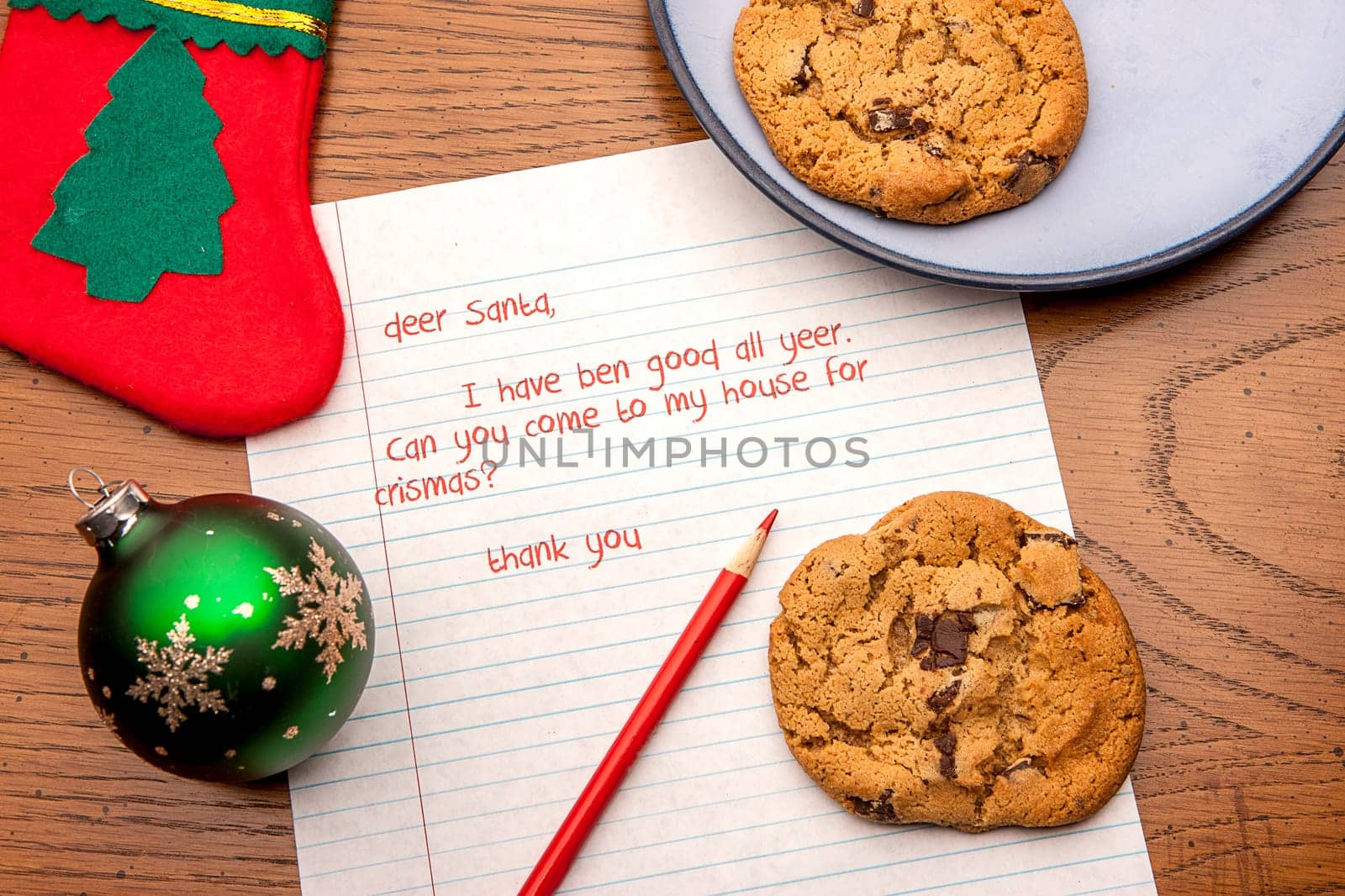 A close up image of a letter to Santa, cookies, and a few decorations.