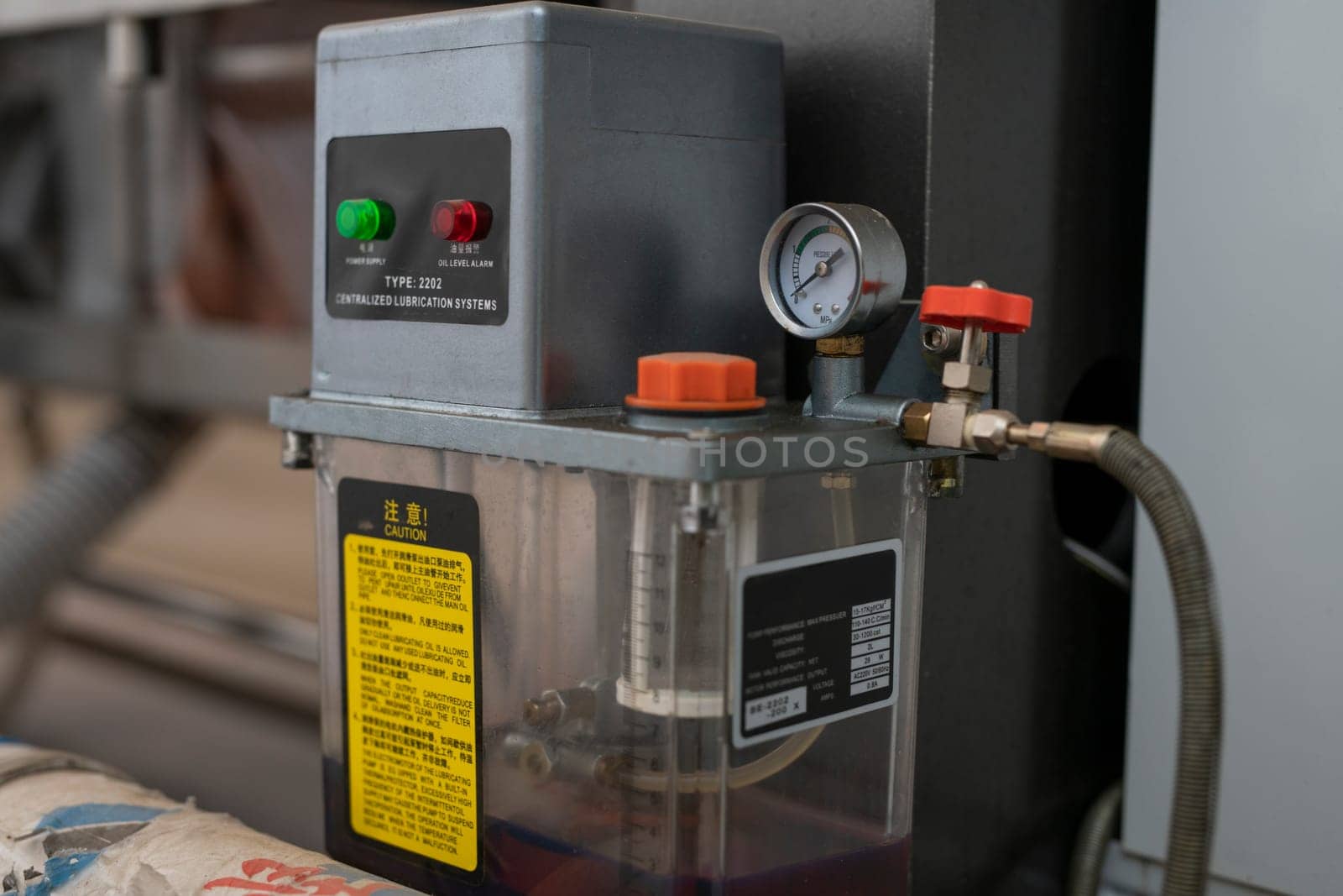Compressor with pressure gauge mounted on automatic glass polishing machine in industrial workshop