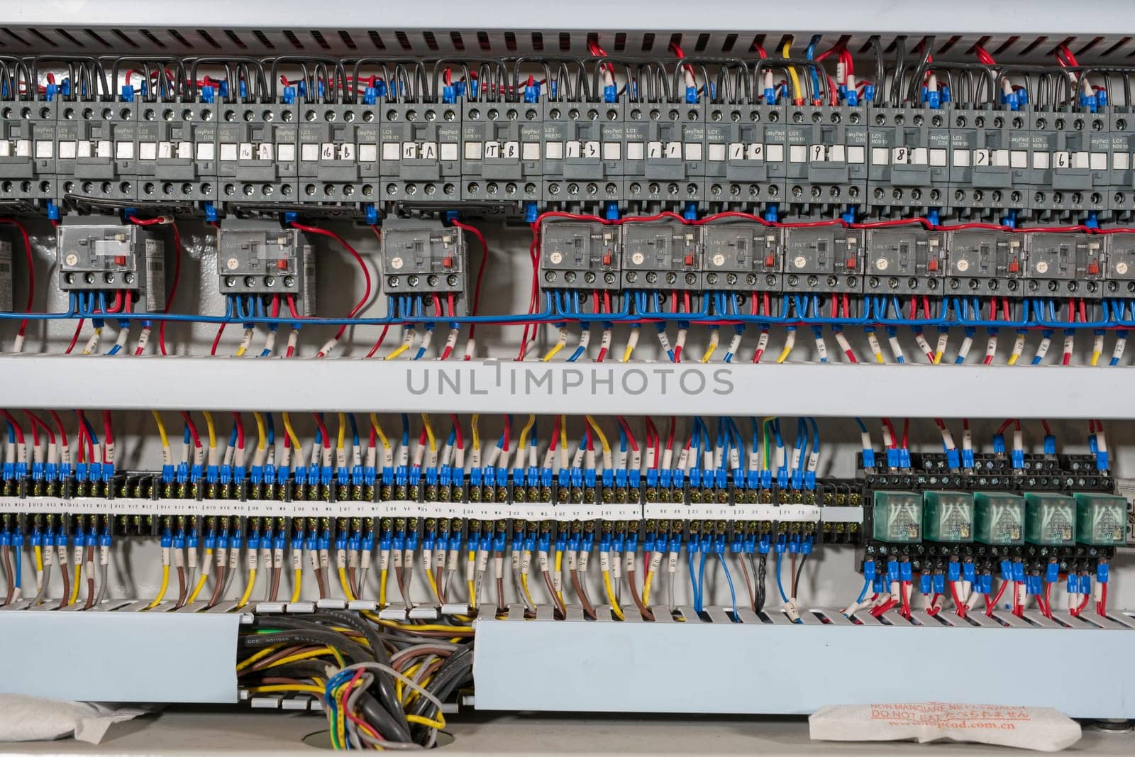 Electronic patch panel with various cables of modern glass polishing machine mounted at industrial factory