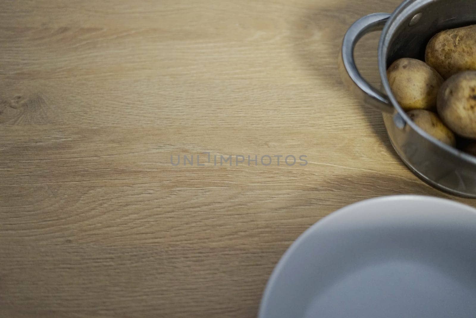 young boiled cooked potatoes skin in pot with plate on wooden background table kitchen dinner lunch meal prepare peel fresh organic dug . High quality photo