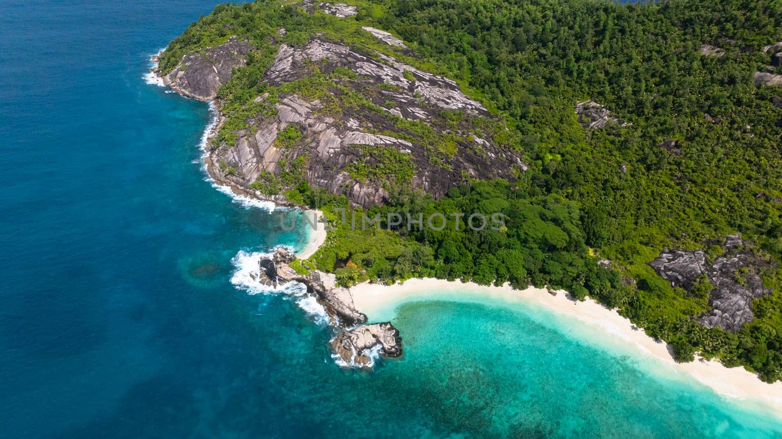 A coastline featuring white sandy beaches, turquoise waters, and rocky hills. Therese. Seychelles, Mahe.