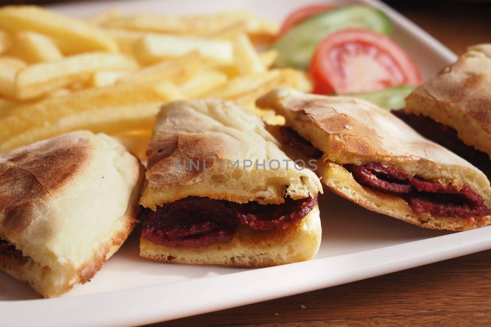 A platter features three sandwiches, crispy fries, and vegetables.