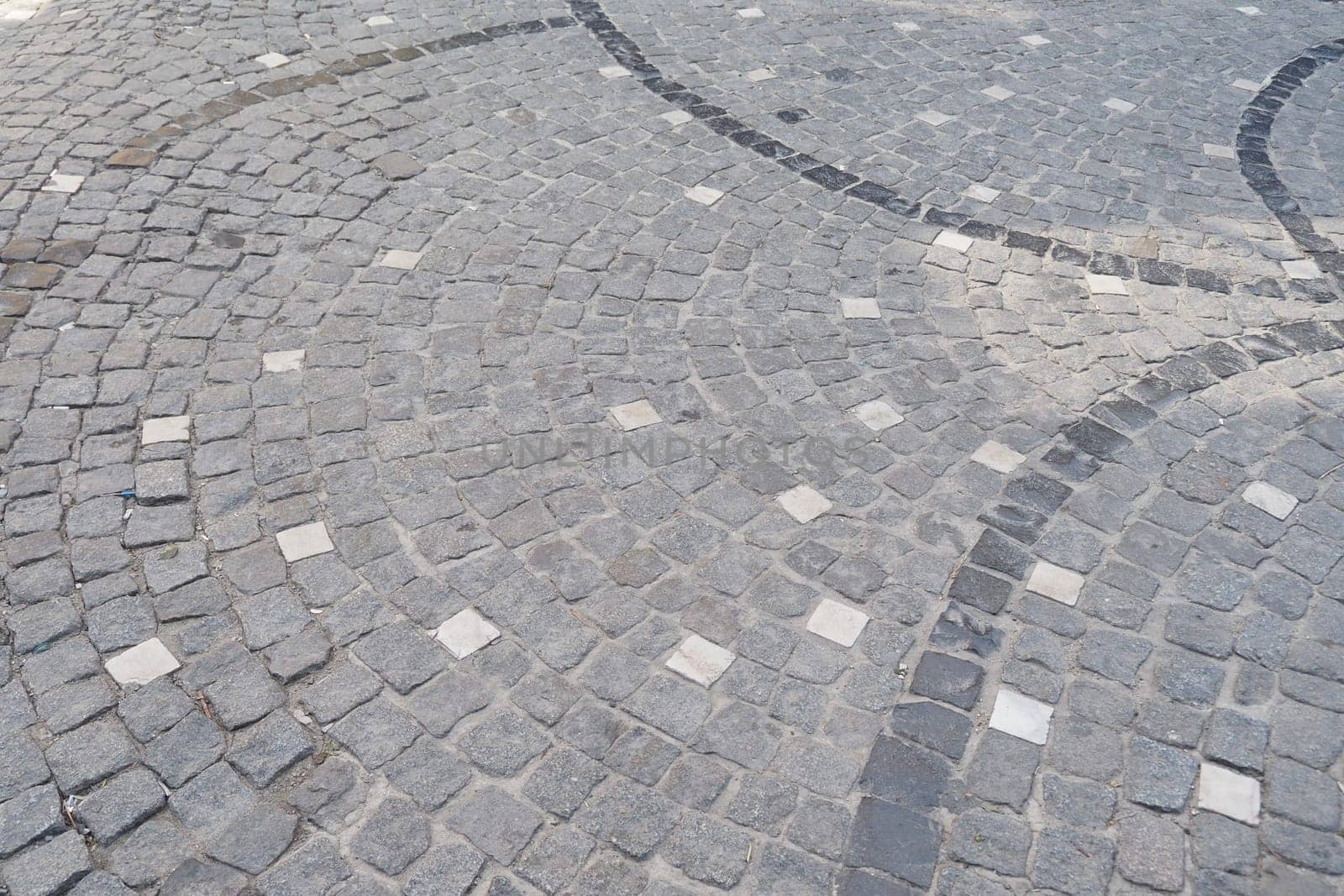 The intricate design of a cobblestone pathway is highlighted on a sunny day.