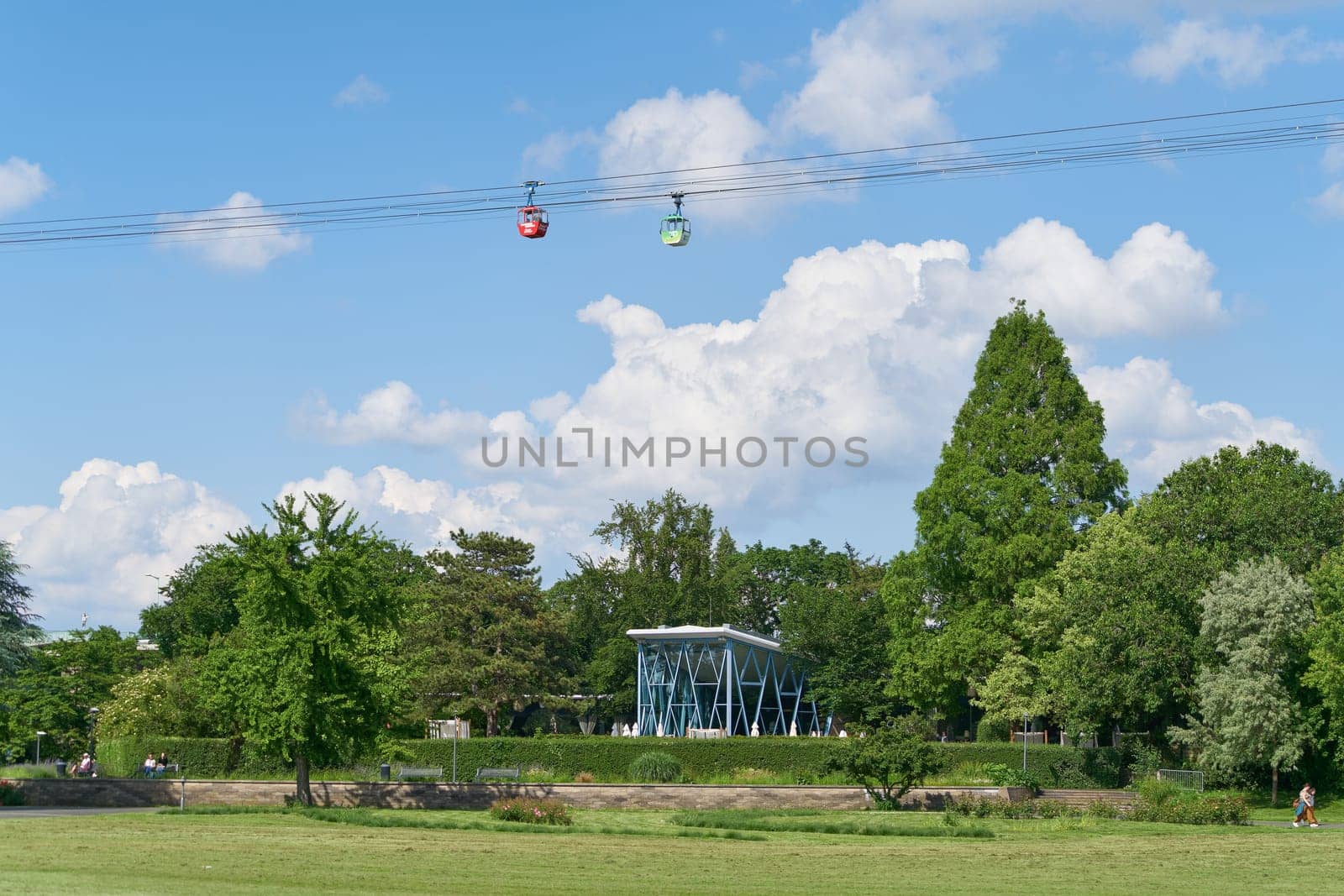 Cologne, Germany – May 23, 2024: the Rhine Park, Rheinpark with gondolas of the Rhine cable car, Rhein Seilbahn on a sunny day in Cologne