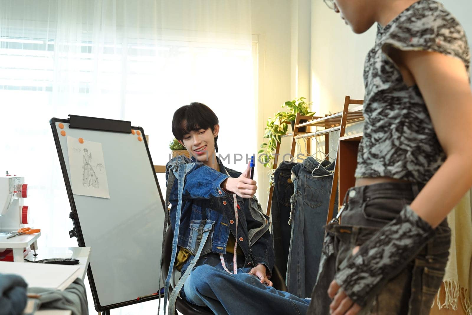 Young fashion entrepreneurs working on a denim project in a bright fashion studio.