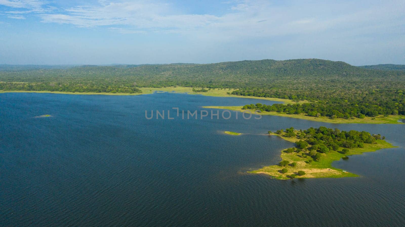Lake in the background of mountains with tropical forest and jungle. Kantale tank, Sri Lanka.