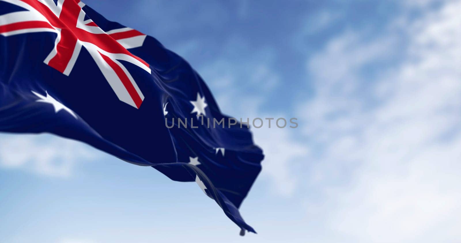 Australia national flag waving in the wind on a clear day. Blue flag with Union Jack, white 5-pointed star symbolizing Southern Cross. 3D illustration render. Selective focus