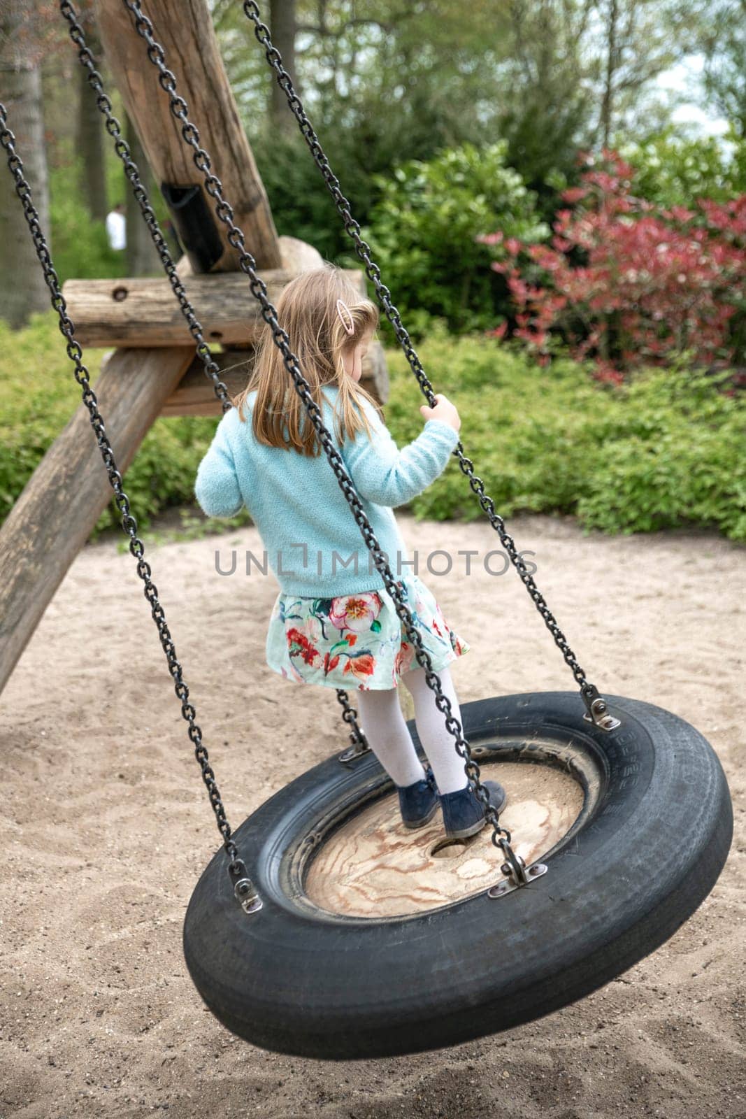 Girl of 4 years old riding on a swing in a park