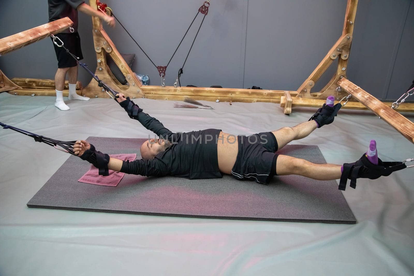 A chiropractor assists a patient undergoing spinal decompression therapy with stretching straps
