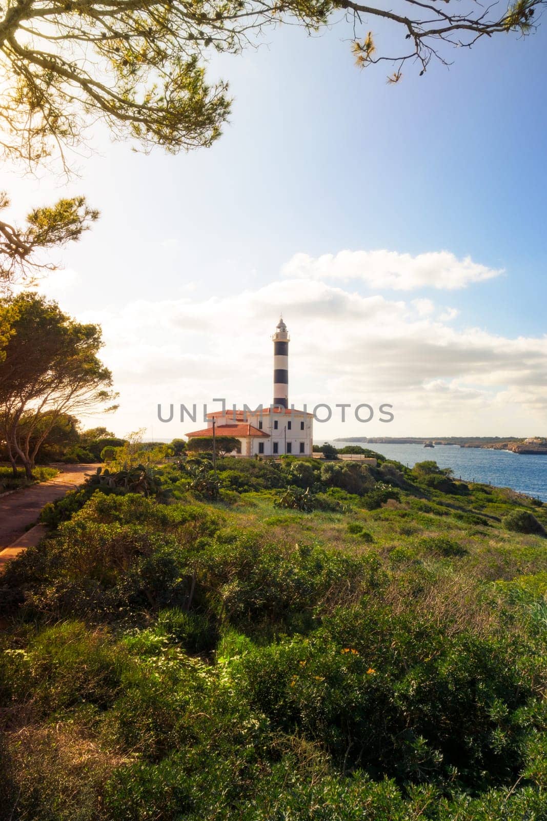 beautiful lighthouse on the cliff in the bay of portocolom at sunrise, mallorca,balearic islands, spain
