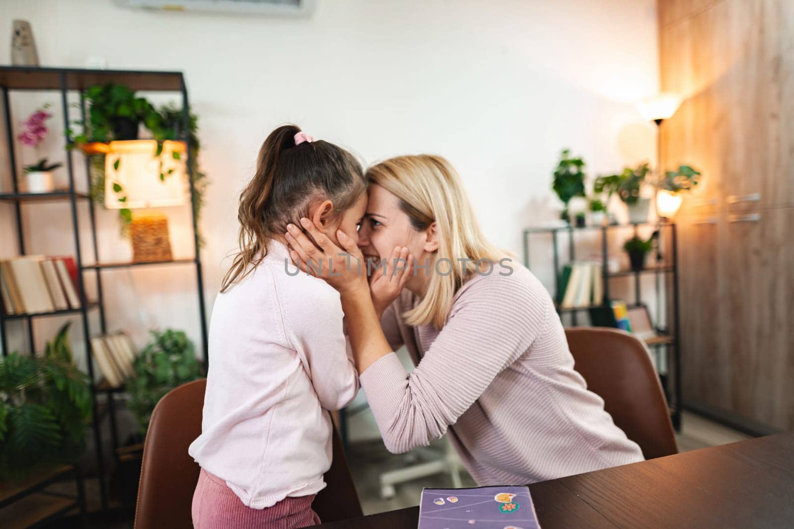 A mother lovingly embraces her daughter, sharing joy and laughter together.