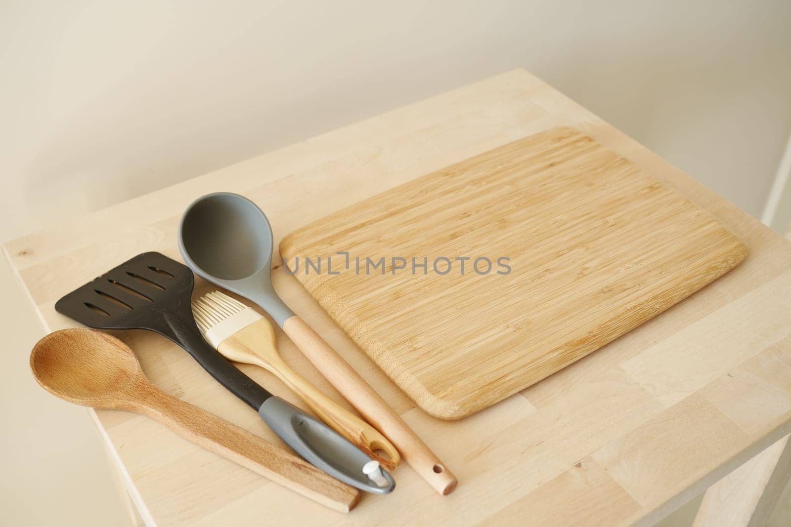 Wooden spatula, spoon, brush, and ladle placed on a chopping board.