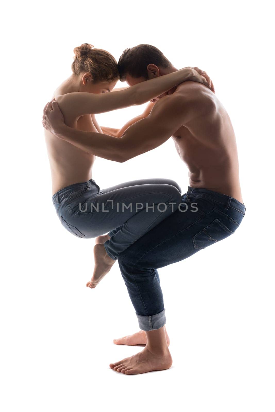 man hold woman on knees while standing on gray background in studio
