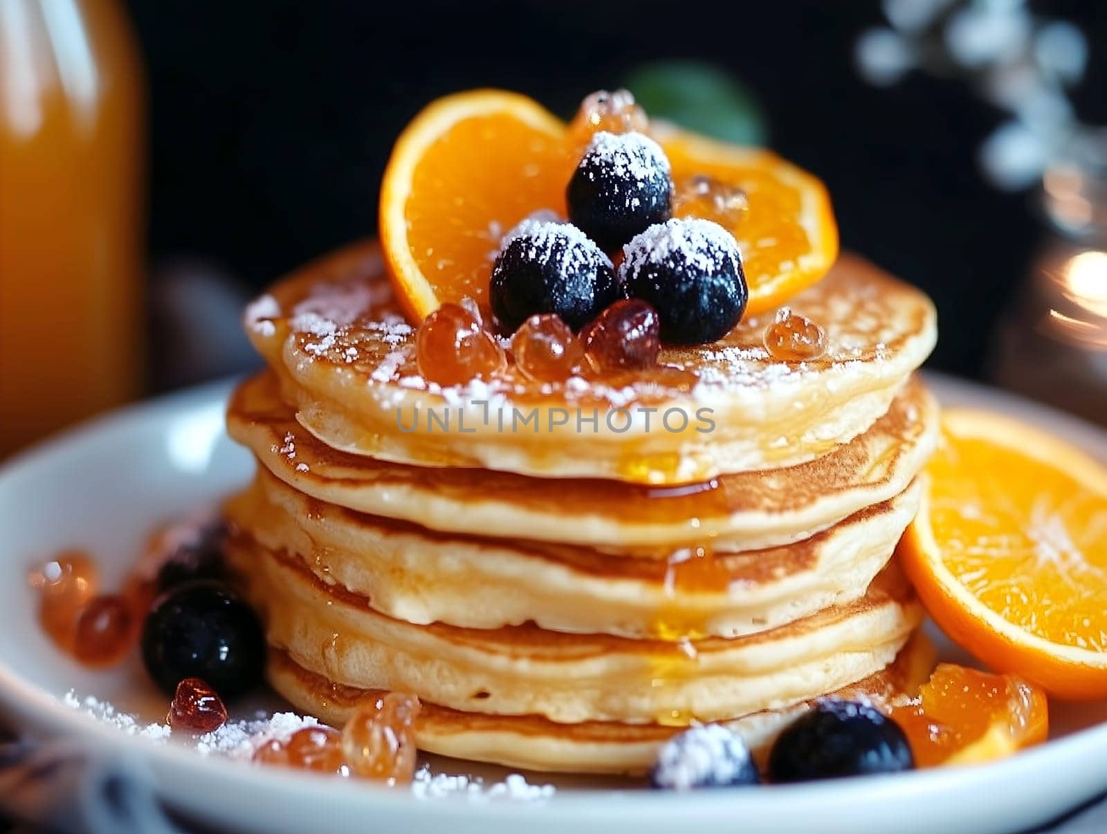 A delicious stack of fluffy pancakes topped with fresh blueberries, orange slices, and syrup drizzle. The warm lighting and powdered sugar create an inviting and indulgent breakfast scene.