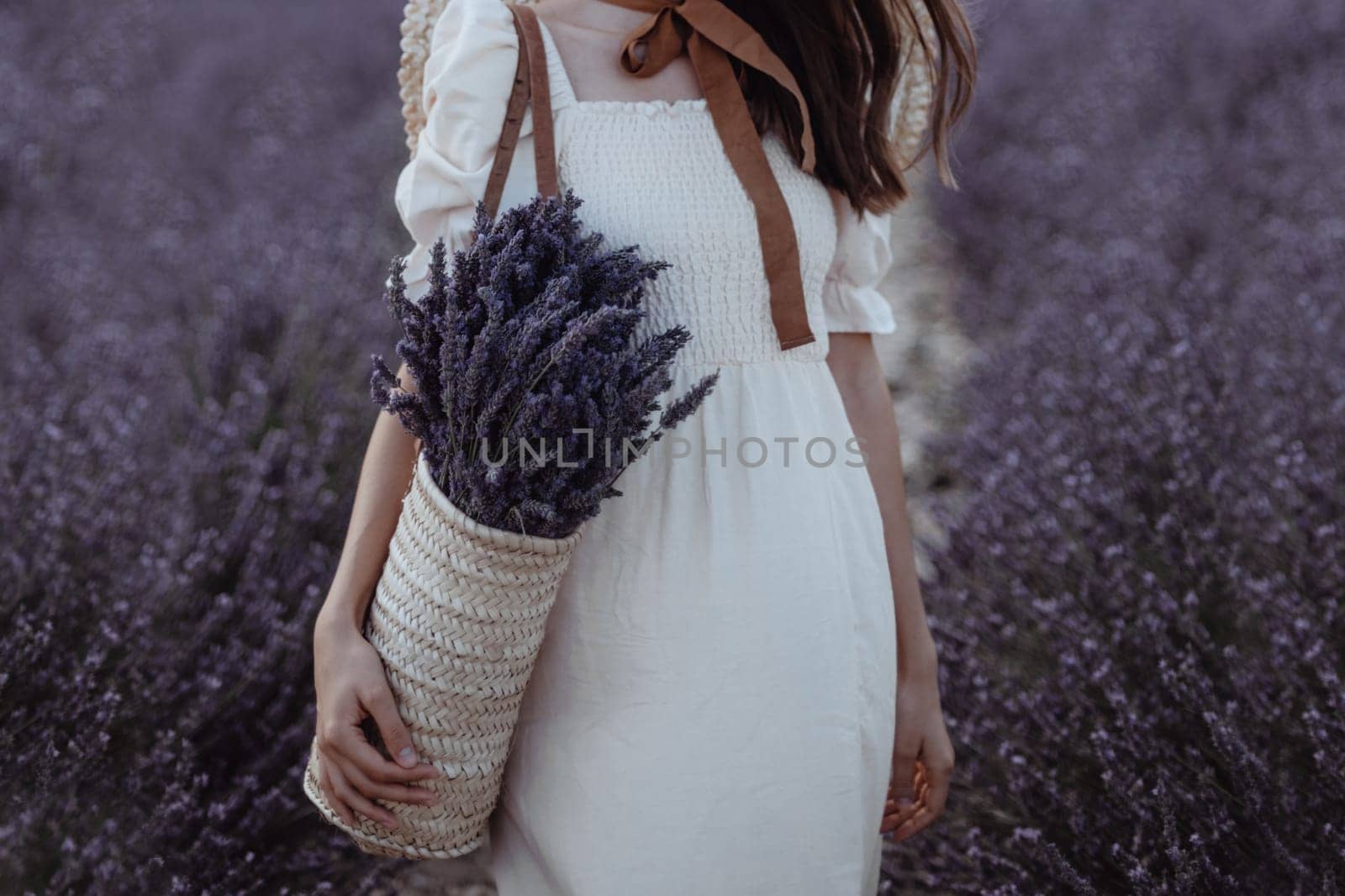 Woman holding wicker basket with a lavender in the field