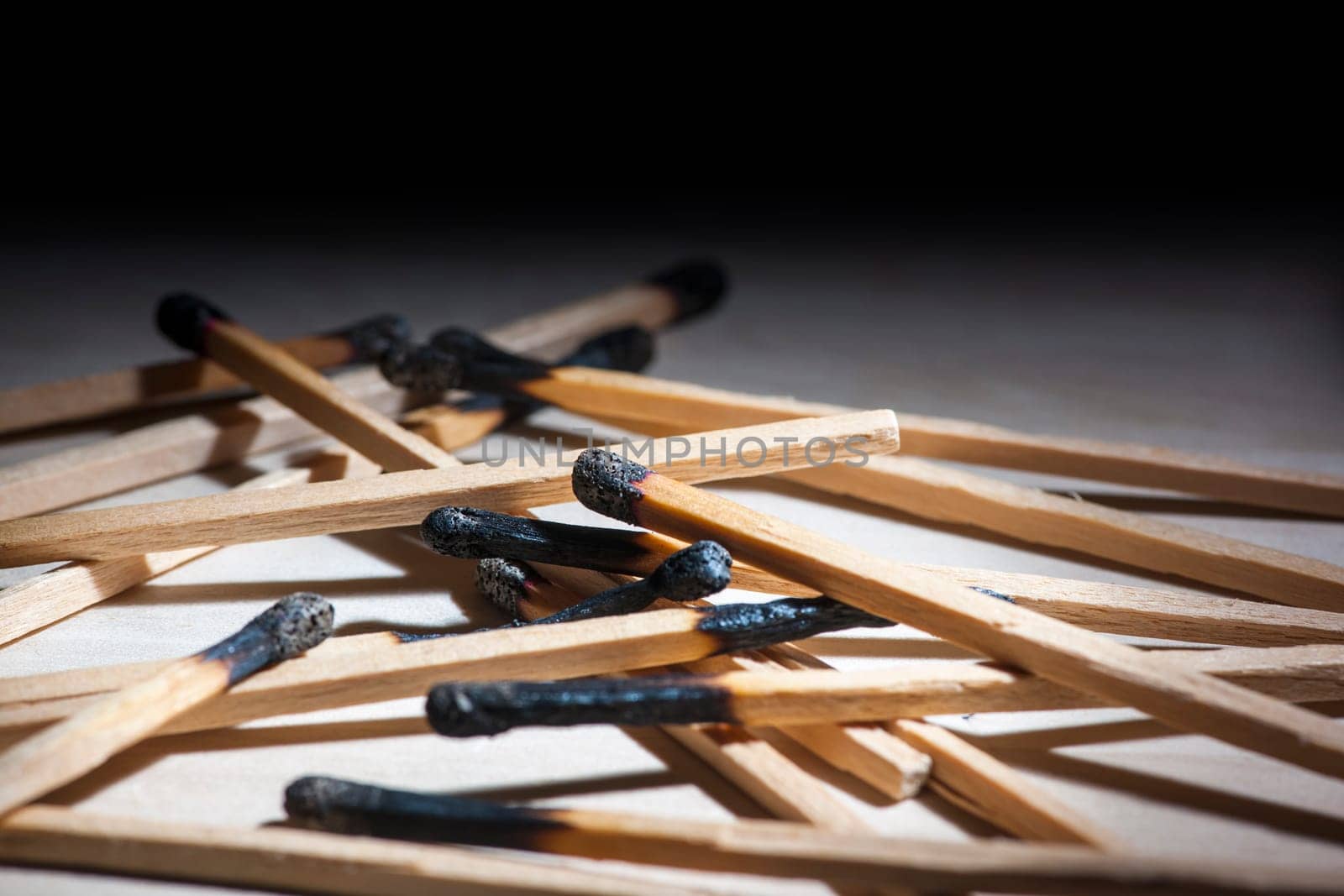 Low angle close-up view of burnt matches on a receding background.
