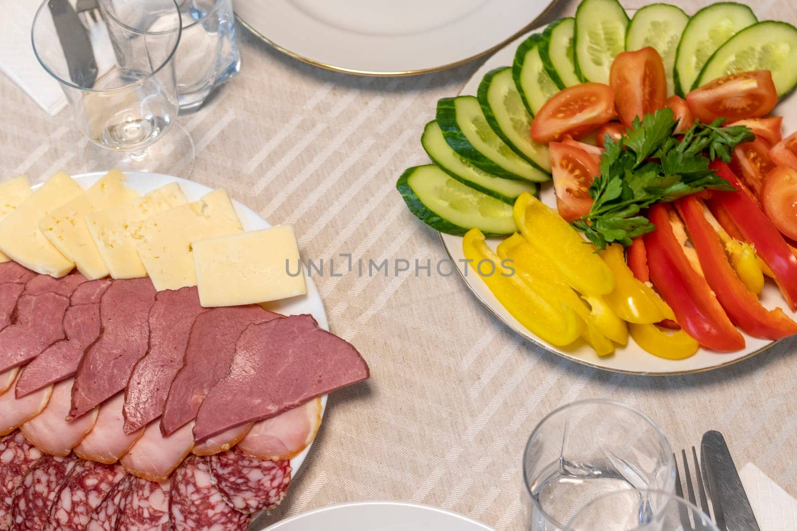 Shot of the table set up with assorted cut fresh vegetables, cold cuts, olives, salads.