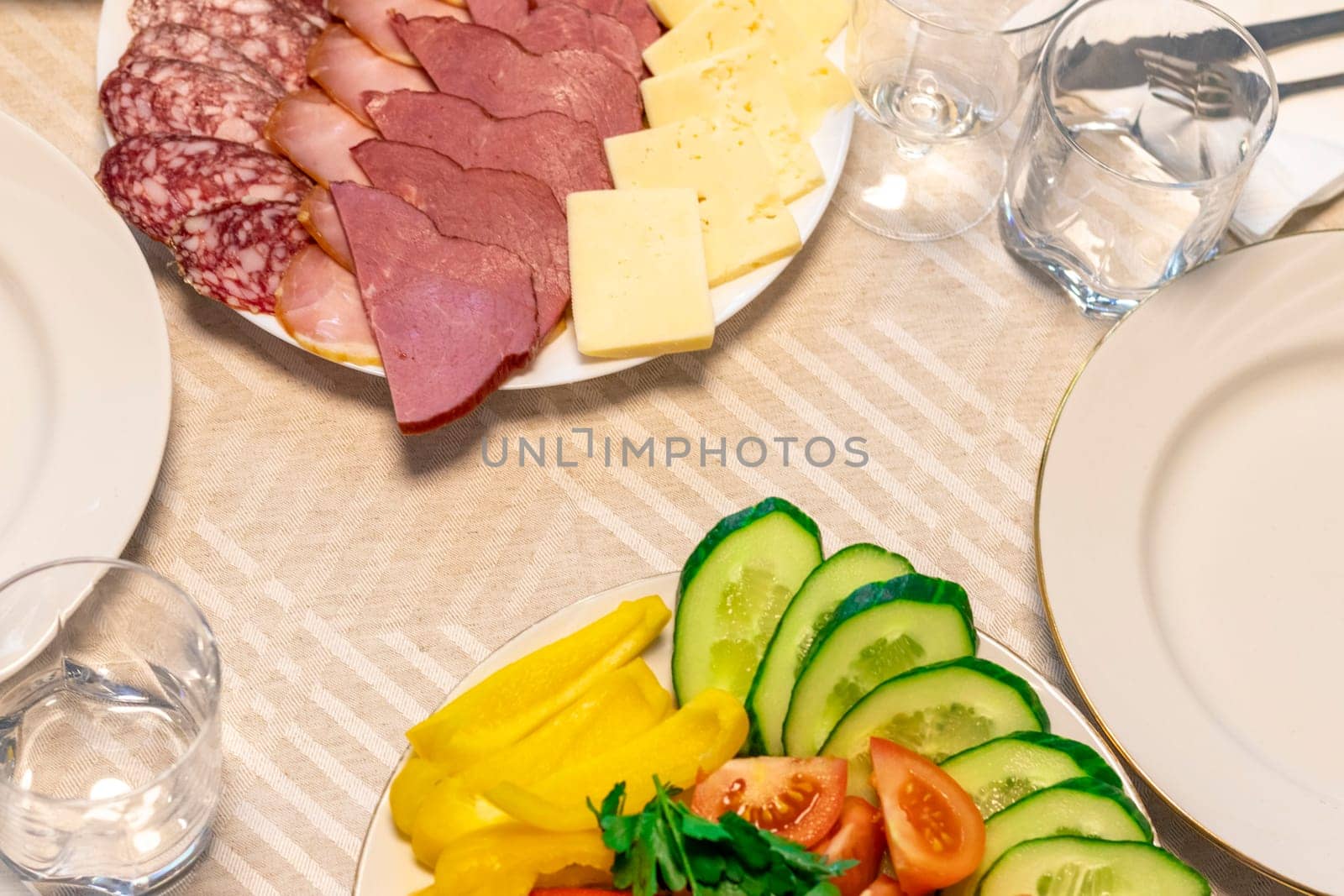 Shot of the table set up with assorted cut fresh vegetables, cold cuts, olives, salads.