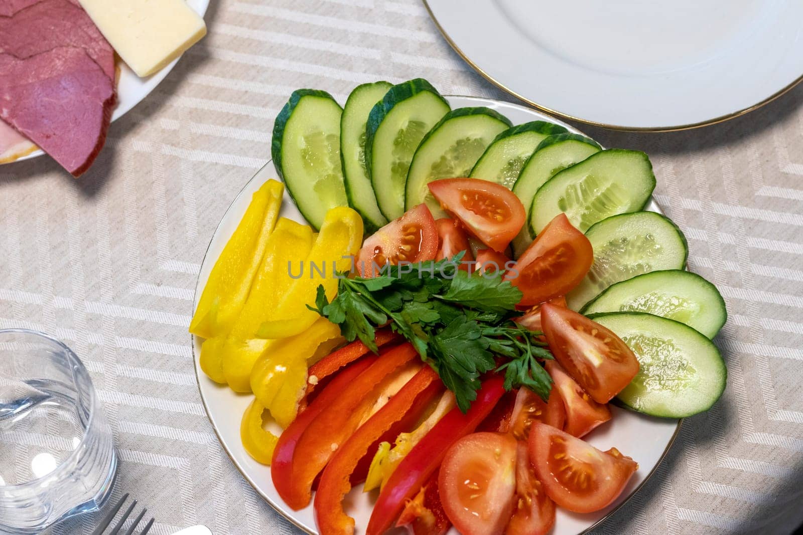 Shot of the table set up with assorted cut fresh vegetables, cold cuts, olives, salads.