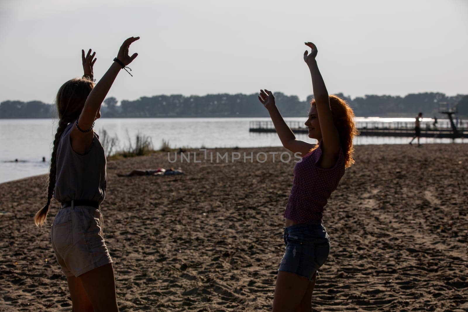 Two close friends are delighting in a blissful day at the beach while capturing the true essence of summer joy