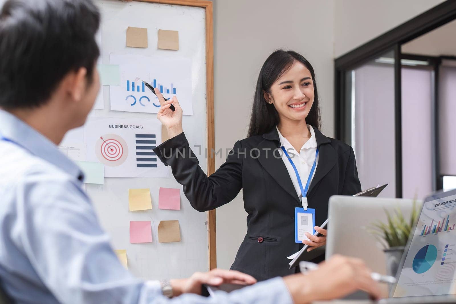 Close up, businesswoman presenting data analysis on a board to her colleagues in the company..