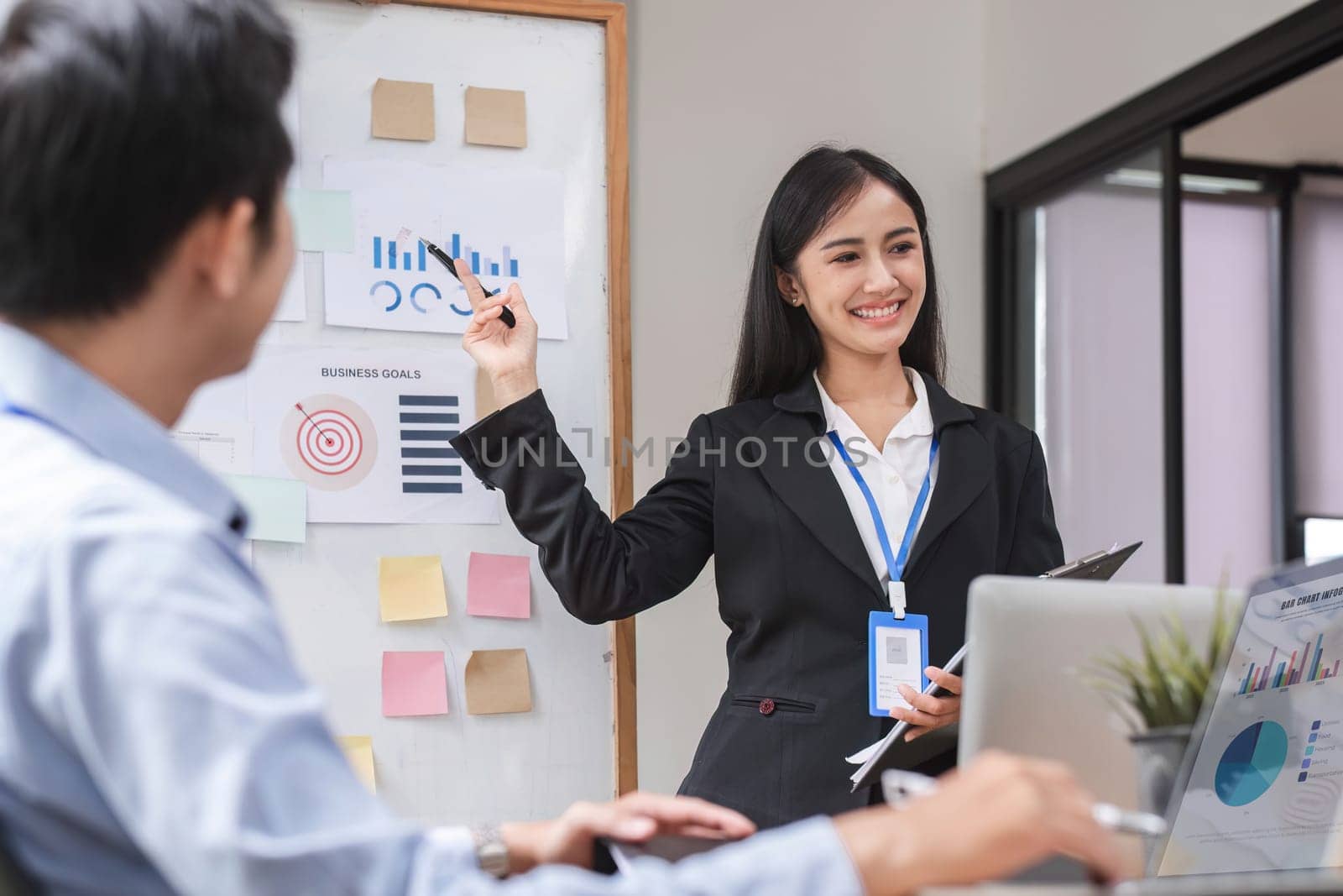 Close up, businesswoman presenting data analysis on a board to her colleagues in the company. by wichayada