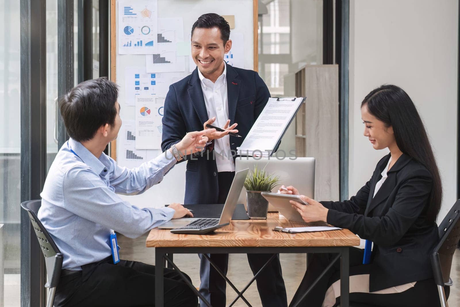 Professional businessman presenting to colleagues in conference room explaining growth chart.