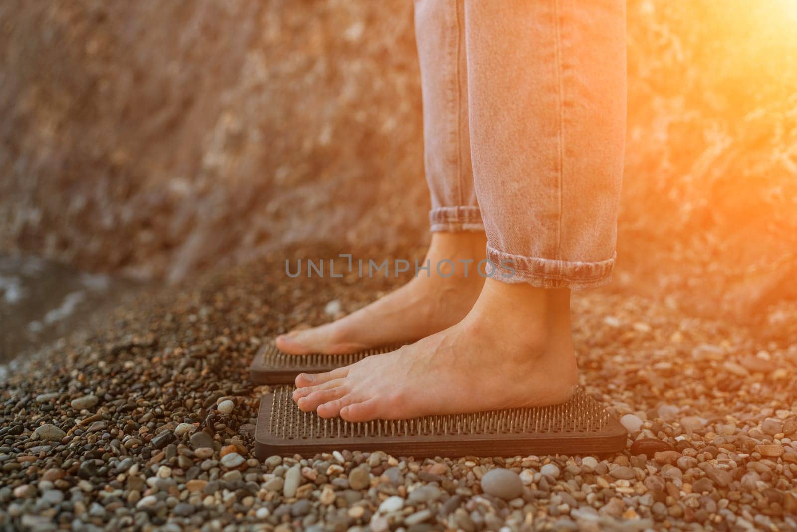 Sea Woman feet stepping on sadhu board during indian practice on the seashore. . Healthy lifestyle concept. tool for working out your inner state by Matiunina