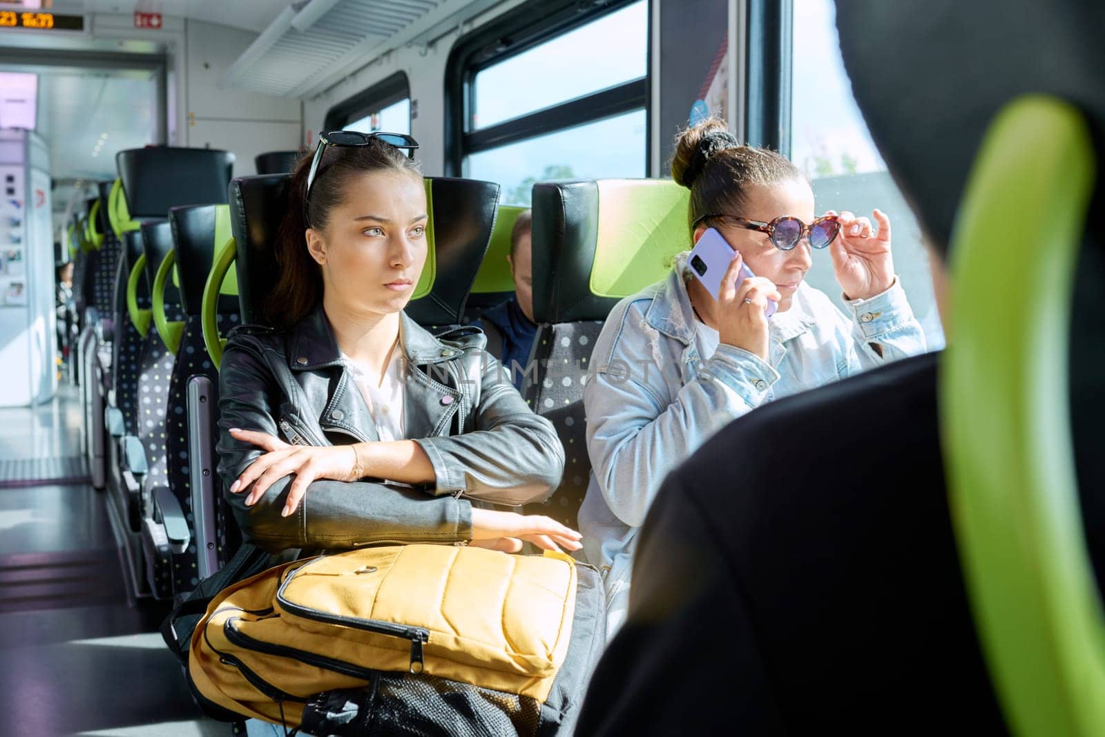 Commuter train passengers, young student girl with a backpack goes to study. City intercity electric railway transport concept