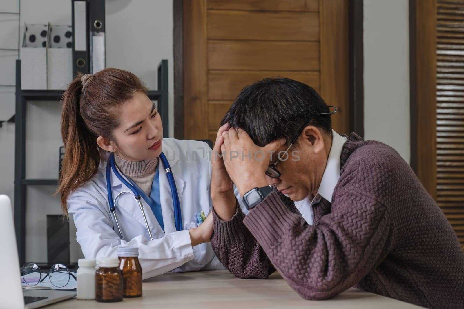 A female doctor is giving advice on diseases and medicine to an elderly male patient. 60s who has a headache Concept of health check and stress disease by wichayada