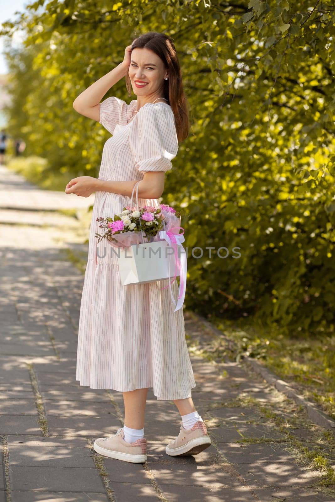 Beautiful girl with flowers, in a dress, glasses and sneakers. by AnatoliiFoto