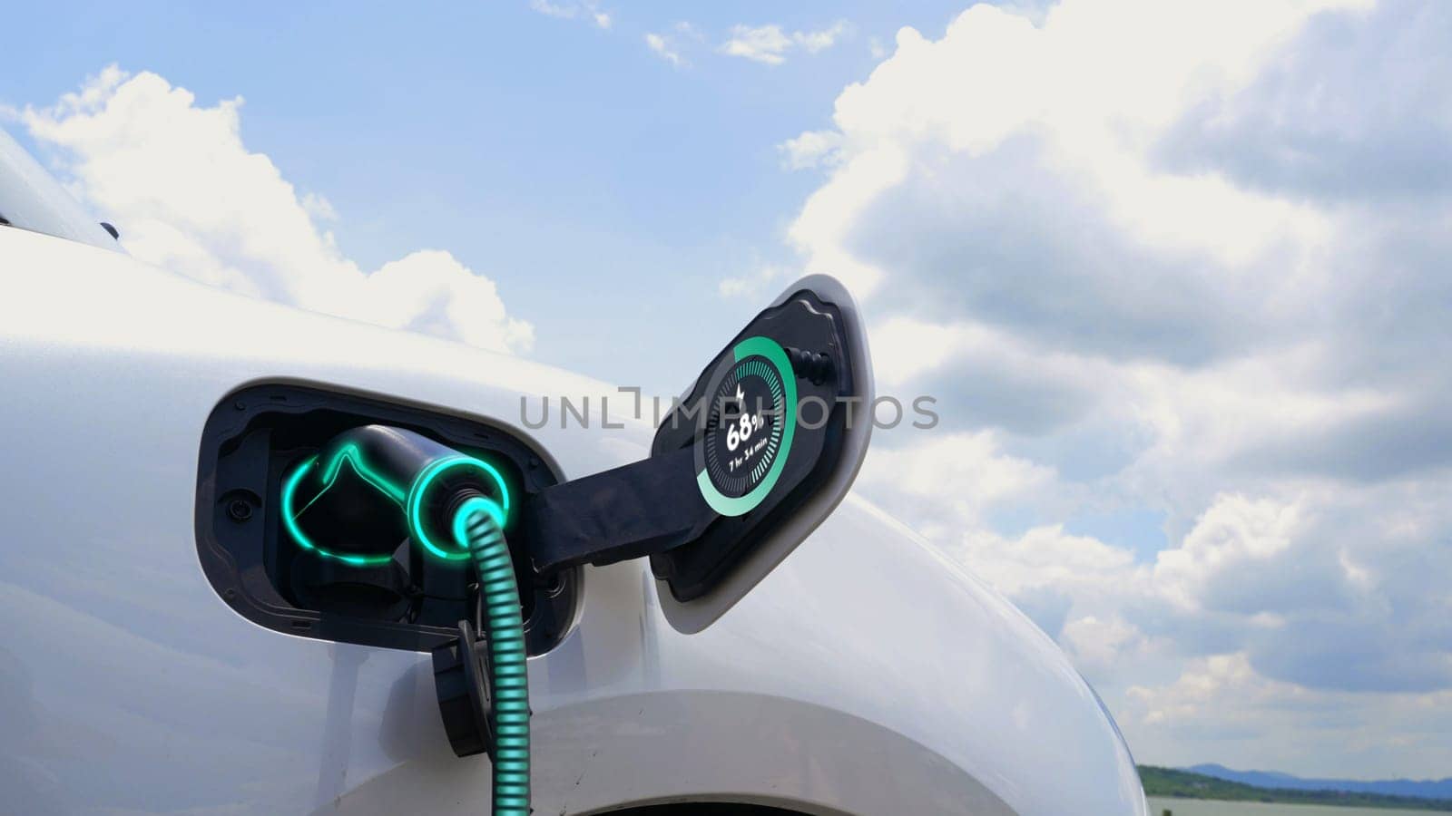 Electric car plugged in with charging station with nature background. Peruse by biancoblue